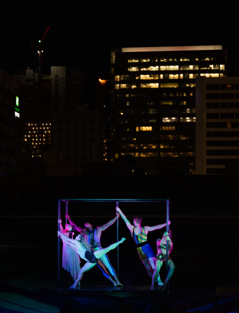 Dancers on the Tarotville stage with downtown buildings in the background